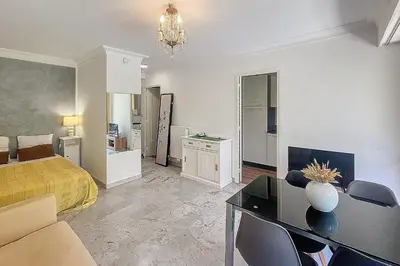 a bedroom with a bed and a table and chairs at Henri Camille Real Estate- Mikaela - Studio with terrace in Cannes