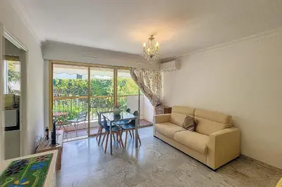 a living room with a couch and a table at Henri Camille Real Estate- Mikaela - Studio with terrace in Cannes