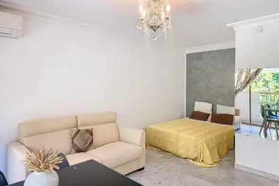 a living room with a couch and a bed at Henri Camille Real Estate- Mikaela - Studio with terrace in Cannes