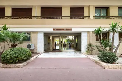 an entrance to a building with palm trees at Suite Ioana - Appartement à Cannes in Cannes