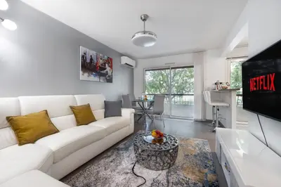 a white bed in a room with a window at Suite Ioana - Appartement à Cannes in Cannes