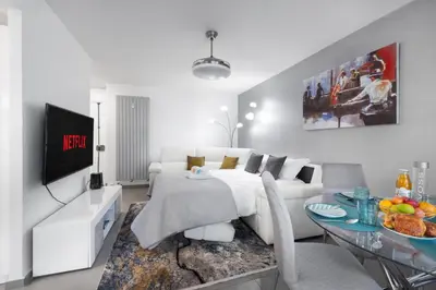 a living room with a white couch and a table at Suite Ioana - Appartement à Cannes in Cannes