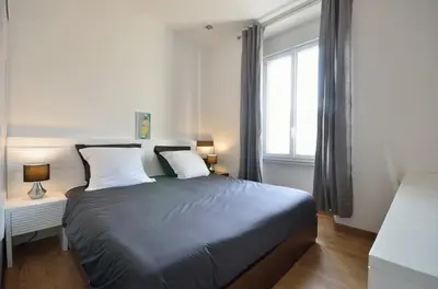a bedroom with a bed with two pillows and a window at Très bel appartement centre-ville in Cannes