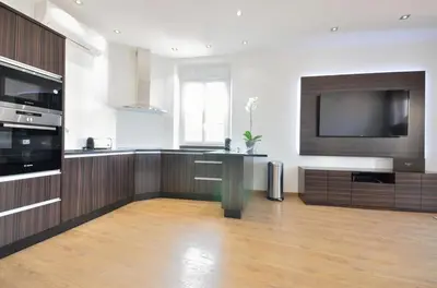 a living room with a large kitchen with a flat screen tv at Très bel appartement centre-ville in Cannes