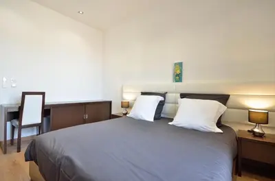 a bedroom with a bed with two lamps and a desk at Très bel appartement centre-ville in Cannes
