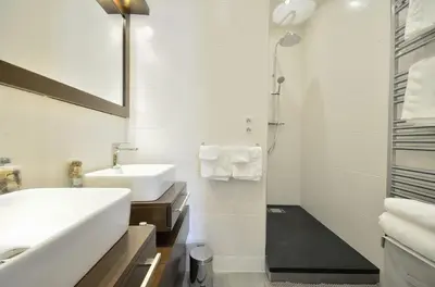 a white bathroom with a sink and a shower at Très bel appartement centre-ville in Cannes