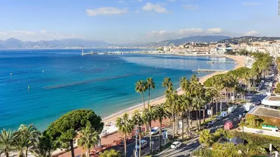 a view of a beach with palm trees and the ocean at 2 Bedrooms appartement entièrement rénové Cannes - 200m de la plage in Cannes