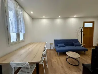 a living room with a blue couch and a wooden table at 2 Bedrooms appartement entièrement rénové Cannes - 200m de la plage in Cannes