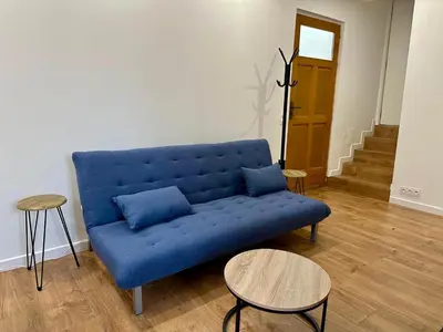 a blue couch in a living room with two tables at 2 Bedrooms appartement entièrement rénové Cannes - 200m de la plage in Cannes