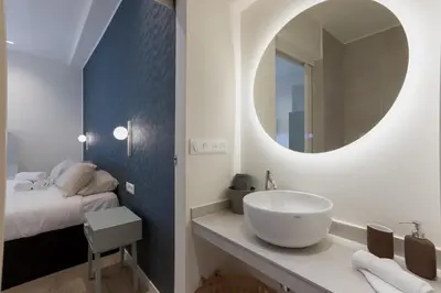 a bathroom with a sink and a mirror and a bed at 14 Vagliano - Palais, plage, clim, hyper-centre in Cannes
