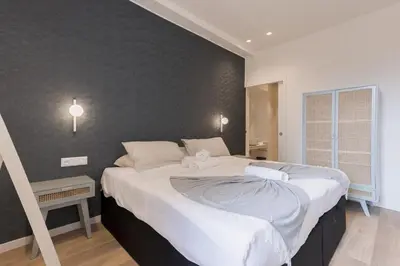 a bedroom with a large bed with white sheets at 14 Vagliano - Palais, plage, clim, hyper-centre in Cannes