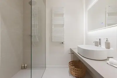 a white bathroom with a sink and a shower at 14 Vagliano - Palais, plage, clim, hyper-centre in Cannes