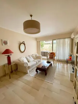 a living room with a couch and a table at appartement avec piscine in Le Cannet