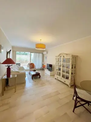 a living room with a couch and a table at appartement avec piscine in Le Cannet