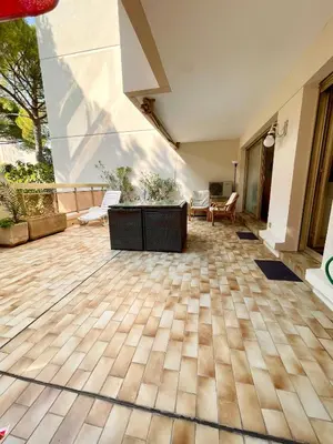 a large room with a wooden floor and a large window at appartement avec piscine in Le Cannet