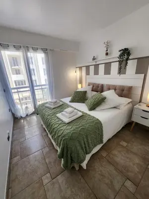 a bedroom with a large bed with a green blanket at Cannes Paradis in Cannes