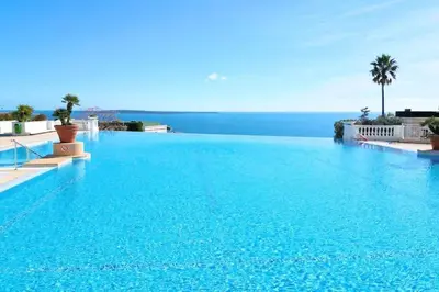 a large blue swimming pool with a view of the ocean at 4 people with Pool Tennis Parking air cond in Cannes