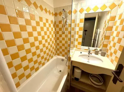 a bathroom with a sink and a tub and a mirror at 4 people with Pool Tennis Parking air cond in Cannes