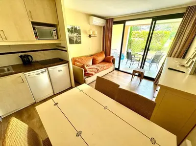 a kitchen and a living room with a couch at 4 people with Pool Tennis Parking air cond in Cannes