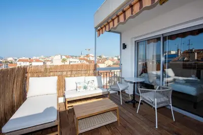 a balcony with a couch and a table on a deck at Studio Merlot - Welkeys in Cannes