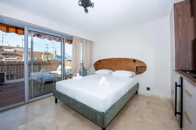 a bedroom with a large bed and a balcony at Studio Merlot - Welkeys in Cannes