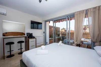 a hotel room with a bed and a large window at Studio Merlot - Welkeys in Cannes
