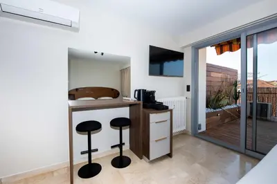 a kitchen with two stools at a counter with a balcony at Studio Merlot - Welkeys in Cannes