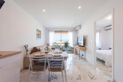 a kitchen and living room with a table and chairs at 1-Br Renovated Near Croisette in Cannes