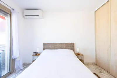 a white bed in a room with a window at 1-Br Renovated Near Croisette in Cannes