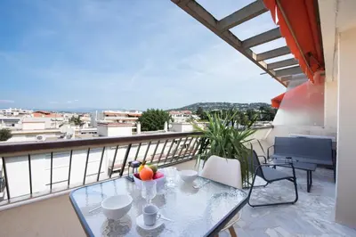 a glass table with a bowl of fruit on a balcony at 1-Br Renovated Near Croisette in Cannes