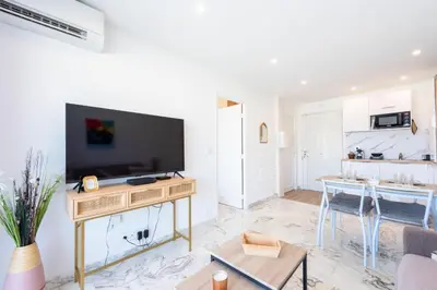 a living room with a television and a table at 1-Br Renovated Near Croisette in Cannes
