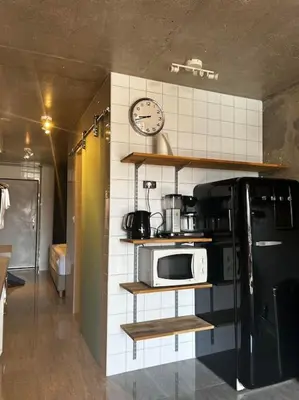 a kitchen with a refrigerator and a clock on the wall at Appartement Cannes, Piscine - vue mer - terasse in Cannes
