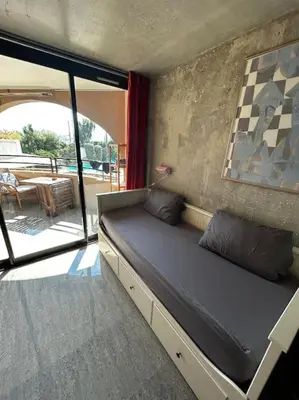 a couch in a room with a view of a patio at Appartement Cannes, Piscine - vue mer - terasse in Cannes
