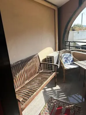 a balcony with a wooden bench and a chair at Appartement Cannes, Piscine - vue mer - terasse in Cannes