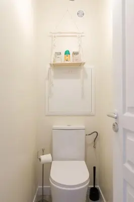 a bathroom with a toilet with a shelf above it at ON VACAY - Votre havre de paix à 100 m des plages in Cannes