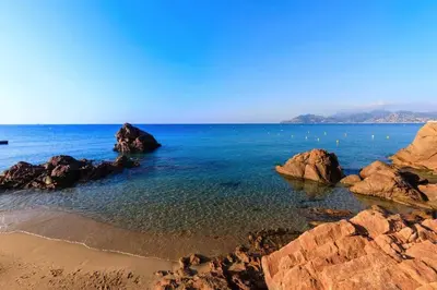 a beach with rocks and the ocean on a clear day at ON VACAY - Votre havre de paix à 100 m des plages in Cannes
