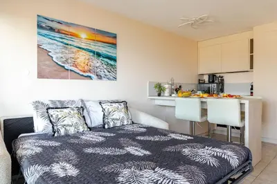 a living room with a bed and a kitchen at ON VACAY - Votre havre de paix à 100 m des plages in Cannes