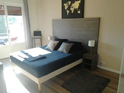 a bedroom with a large bed with a wooden headboard at Appartement cannes in Le Cannet