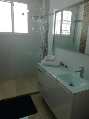 a white bathroom with a sink and a shower at Appartement cannes in Le Cannet