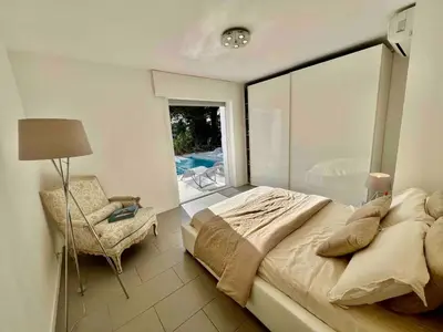 a bedroom with a large bed and a chair at Villa MARGARITTA 4km Cannes centre et plages in Le Cannet