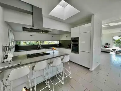 a kitchen with white cabinets and white stools at Villa MARGARITTA 4km Cannes centre et plages in Le Cannet