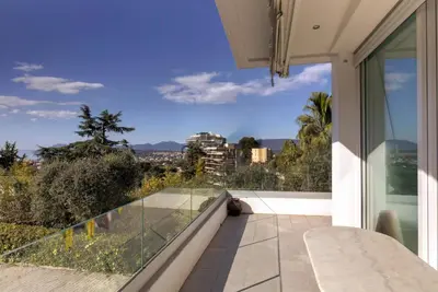 a balcony with a view of the city at Villa MARGARITTA 4km Cannes centre et plages in Le Cannet
