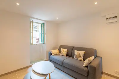 a living room with a couch and a window at La Suquétane - Appt proche plage Cannes in Cannes