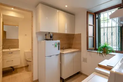 a kitchen with a white refrigerator and a sink at La Suquétane - Appt proche plage Cannes in Cannes