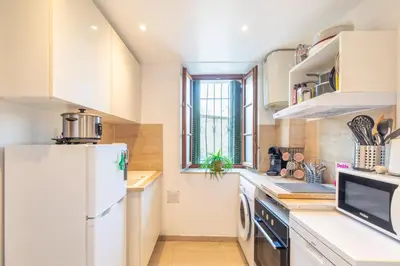 a kitchen with white cabinets and a refrigerator at La Suquétane - Appt proche plage Cannes in Cannes