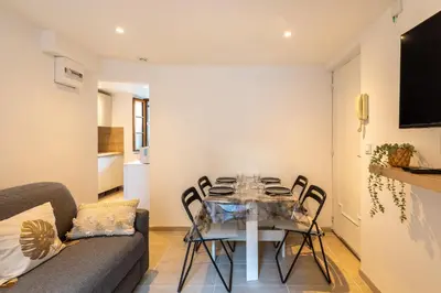a dining room with a glass table and chairs at La Suquétane - Appt proche plage Cannes in Cannes
