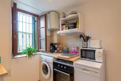a kitchen with a washer and dryer and a window at La Suquétane - Appt proche plage Cannes in Cannes