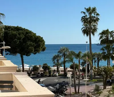 a view of a street with palm trees and the ocean at Cannes Croisette Miramar escape in Cannes