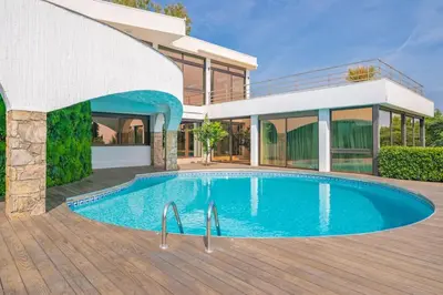a swimming pool in front of a house at Villa Emilia, vue mer, Super-Cannes in Vallauris