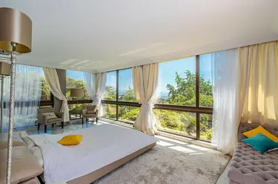 a bedroom with a bed and a large window at Villa Emilia, vue mer, Super-Cannes in Vallauris